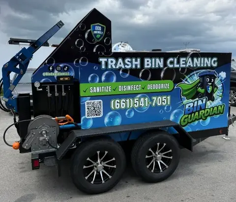The actual Bin Guardian trash bin cleaning trailer with its blue and green branding, lift system, hoses, and wastewater equipment